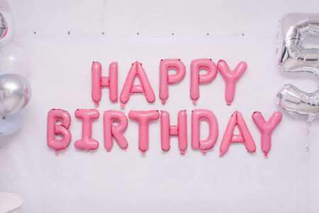 Pink garland of foil balloons "happy birthday" on holidayの写真素材