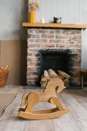 A toy wooden horse-stroller in the cozy interior of the living roomの写真素材