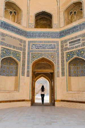 Bukhara, Uzbekistan. March 2022. The girl stands with her back in the doorway of the Kalyan Minaretのeditorial素材