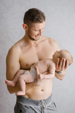 A happy father holds a newborn baby in his armsの写真素材