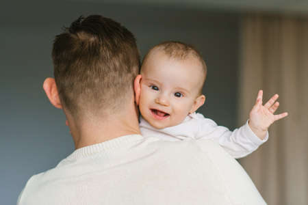 Happy smiling baby in Dad's arms