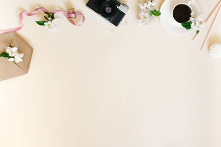 Flat female home office desk for ladies. Workspace with retro camera, coffee cup and apple blossoms...