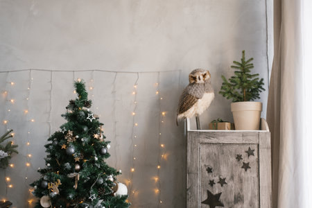 Living room interior, decorated for Christmas and New Year. Owl on the closet, Christmas tree with lightsの写真素材