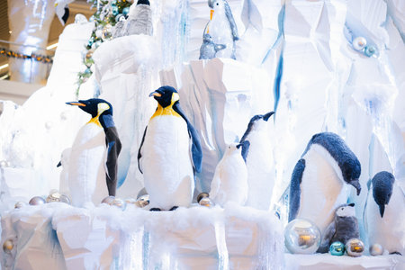 Christmas decor. Ornamental penguins on an artificial iceberg made of snow and ice