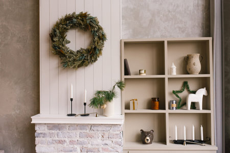 Christmas decor in the bedroom or living room with a wardrobe with open shelves and souvenirs and a wreath on the wallの写真素材