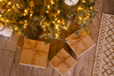 Gift boxes with ribbons and bows under the Christmas tree with lights