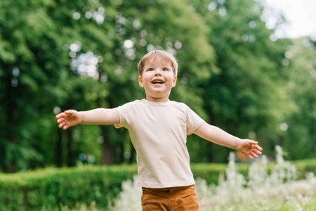 Emotional portrait of a three-year-old boy having fun in a summer parkの写真素材