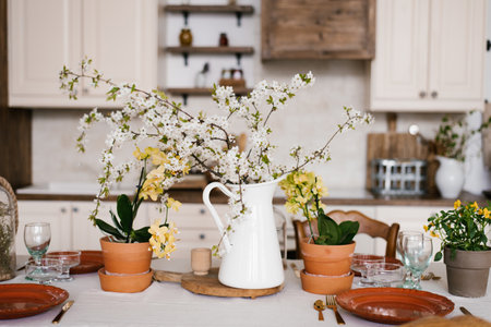 Blooming branches of spring trees in a white vase jug in the Scandinavian-style kitchen decorの写真素材