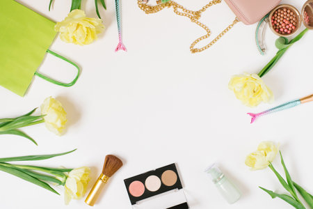 Decorative flat lay composition fashion blogger with makeup products, cosmetics and flowers. Flat lay, top view on white background, copy spaceの写真素材