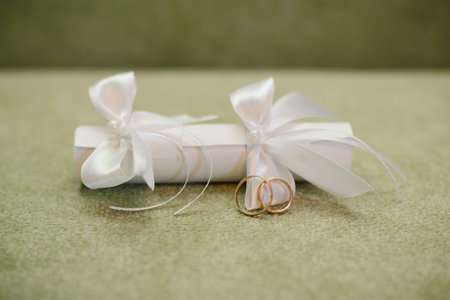 Wedding invitation with a straw with white bows and wedding ringsの写真素材