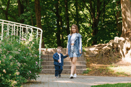 Happy family mom and little son on a spring walk in the parkの写真素材