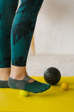 Massage of women's feet with a massage tool ball for myofascial therapyの写真素材