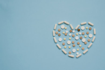 Heart symbol in the format of various tablets highlighted on a blue background with copy space. view from above. The concept of cardiology and healthの写真素材