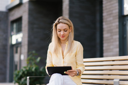 Attractive woman in white trousers and a yellow linen shirt, walking through the streets of the city...