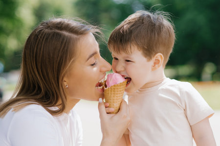 Young mom and son enjoying their summer holidays and eating ice cream