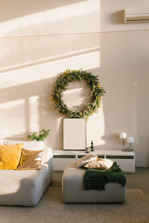 Christmas interior of a Scandinavian modern living room. Sofa and wreath on the wallの写真素材