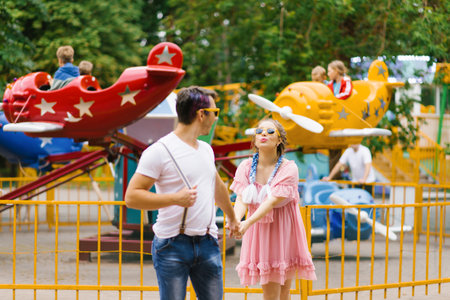 Cheerful couple walking in an amusement parkの写真素材