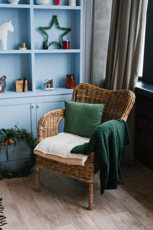 Wicker armchair with a pillow and a green plaid at a blue cafe with a Christmas decorの写真素材