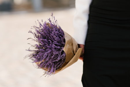 Purple bouquet in the hands of a woman close-upの写真素材