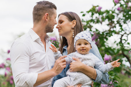 Loving happy family with a young son is having fun in a blooming spring park. outdoor weekends