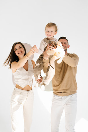 Happy family has fun together. Dad lifts his son up in his arms, and mom smilesの写真素材