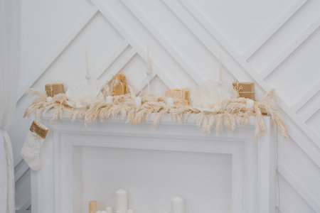 White mantle with fireplace and candles, few gifts for Christmasの写真素材