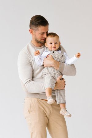 Man is holding a child in his arms. The picture captures a warm and loving moment between father and son on Father's Dayの写真素材