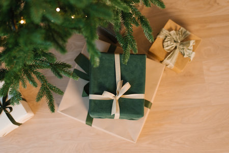 Green christmas gift with a bow on top of a stack of other boxesの写真素材