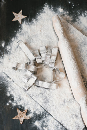 Silver cookie cutter is on top of a pile of flourの写真素材