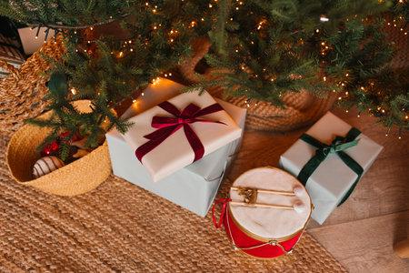 Christmas tree with presents underneath it, stacked on top of each other, with one of them being a drum. The scene is festive and joyfulの写真素材