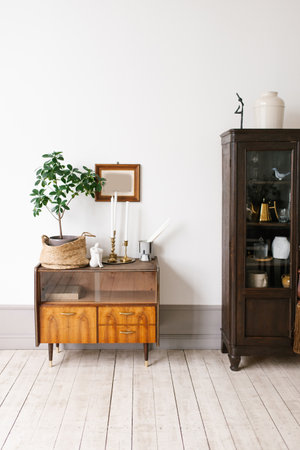 Small wooden table with plant on it and basket and large wooden cabinet in living room