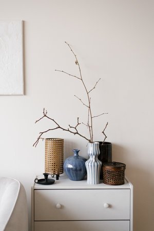 White dresser with blue and brown vase on top of it in modern Scandinavian living room