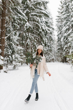 Caucasian woman is walking in snow with bouquet of flowersの写真素材
