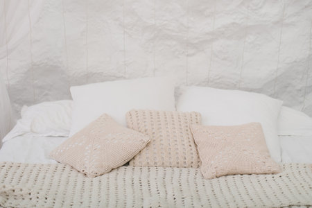 Cozy bed with white pillows and blanketの写真素材