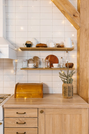Kitchen with wooden countertops and shelves. Vase with Christmas wreaths of firの写真素材