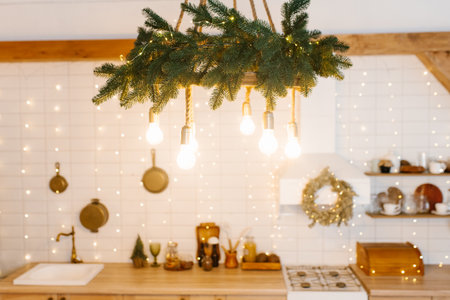 Kitchen with a Christmas wreath on the wall and a festively decorated lamp hanging from the ceilingの写真素材