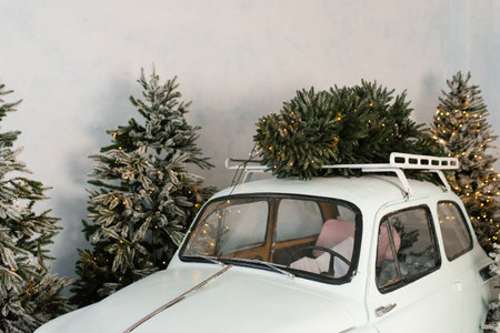 Retro mint car is decorated with Christmas trees on its roofの写真素材