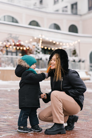 Young mother and her child are standing on the sidewalk.の写真素材