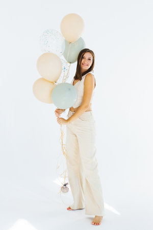 Young happy woman is holding a bunch of balloons in her handの写真素材