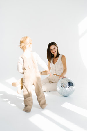 Mother and father are playing with a shiny ball. Lighthearted and playful, with the woman and child enjoying their time togetherの写真素材