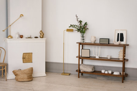 Scandinavian minimalistic living room with fireplace and wooden shelf with vaseの写真素材