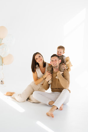 Happy family of three, mom, dad and three year old son posing for a photo shootの写真素材