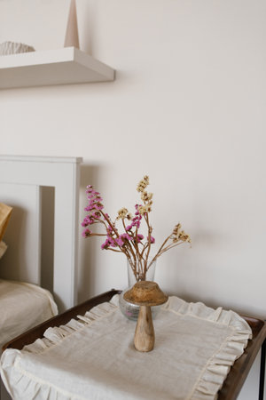 Vase with flowers sits on a table next to toy mushroom