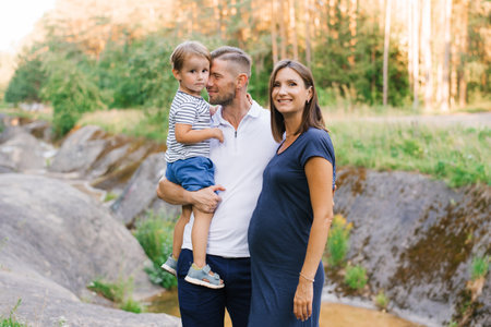 A candid family moment capturing love and laughter in a lush outdoor location, perfect for cherishing summer memories.の写真素材