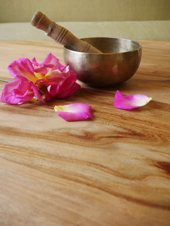 Singing metal bowl to relax and receive healing vibrations, the rose adds freshness to the meditation sessionの写真素材