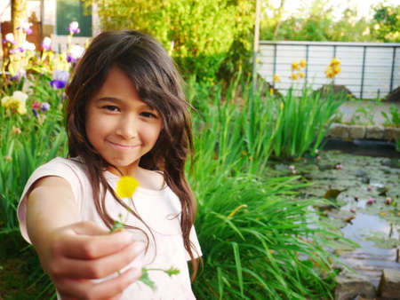 Pretty little girl who is happy to spend time in her garden and enjoy the spring season.の写真素材