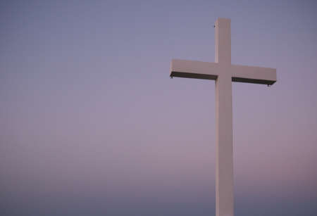 Metal religious cross over a hilltop during a sunset. Copy spaceの写真素材
