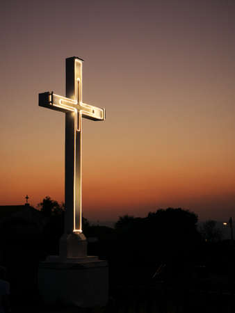 Metal religious cross over a hilltop during a sunset. Copy spaceの写真素材