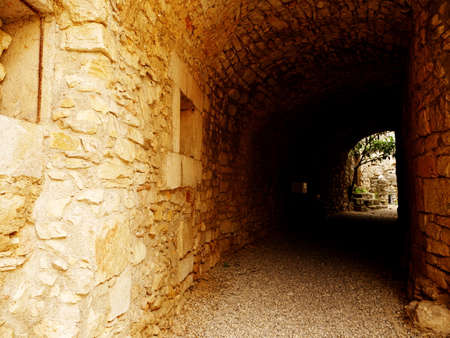 Dark corridor outside in stone in an old villageの写真素材