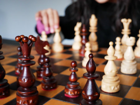 Close-up of the pawns of a chess game with a player in the background